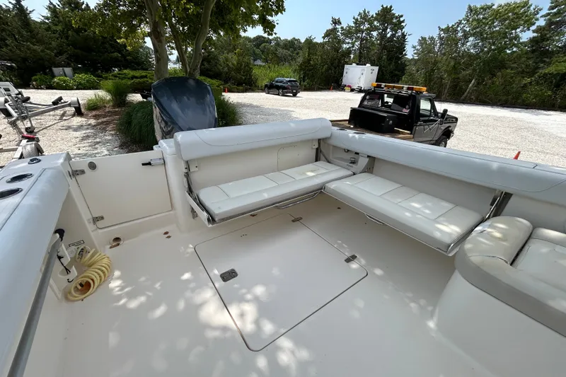 Slide: The Image of The image shows the cockpit of a 2012 Pursuit DC 265 Dual Console boat with white seating. - 10