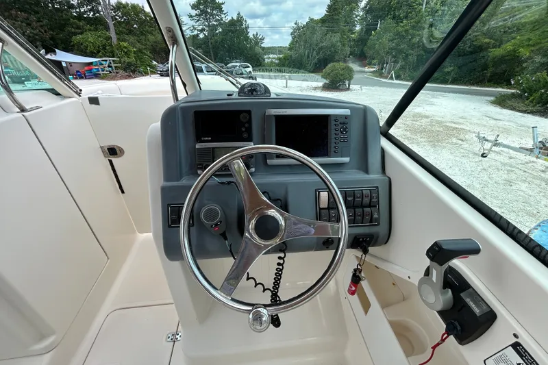 Slide: The Image of Helm of 2012 Pursuit DC 265 Dual Console boat with steering wheel and control panel. - 18