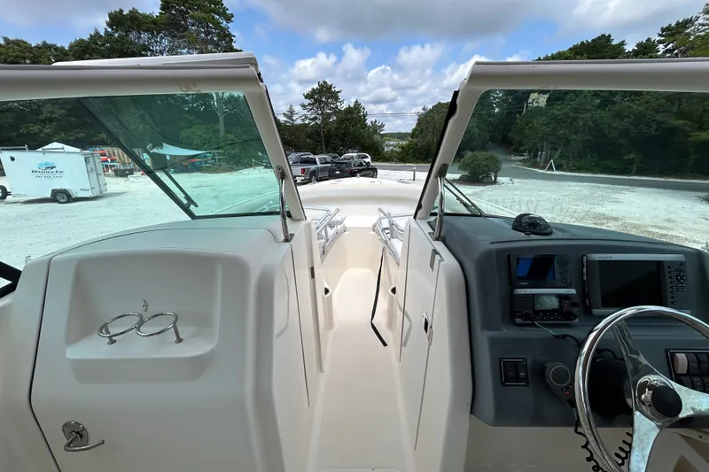 Slide: The Image of 2012 Pursuit DC 265 Dual Console boat interior with steering wheel and dashboard controls. - 20