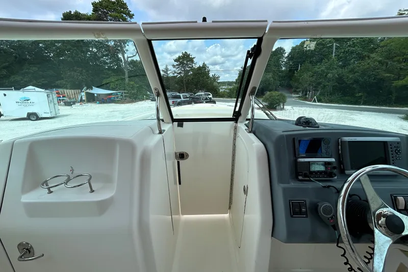 Slide: The Image of 2012 Pursuit DC 265 Dual Console boat interior with steering wheel and navigation equipment. - 19