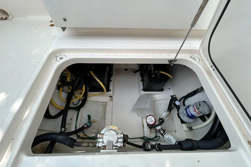Slide: The Image of 2012 Pursuit DC 265 Dual Console boat compartment with wiring and mechanical components. - 25