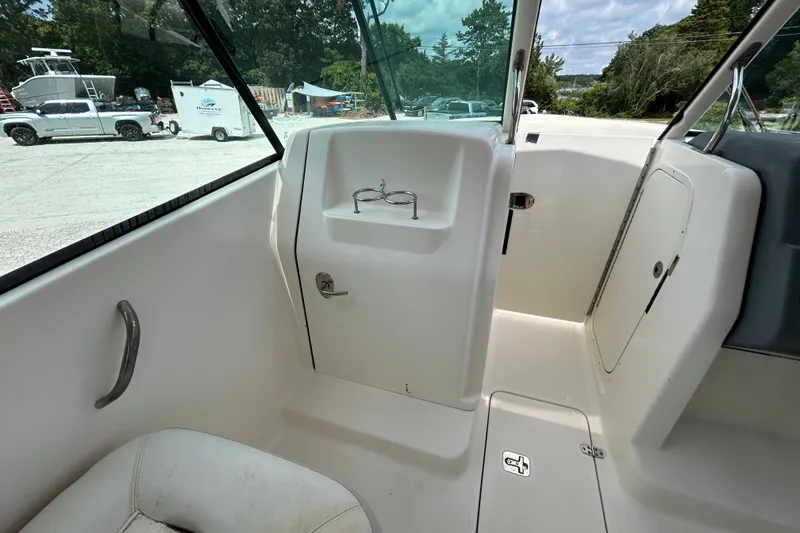 Slide: The Image of Interior view of a 2012 Pursuit DC 265 Dual Console boat, showcasing seating and storage. - 15