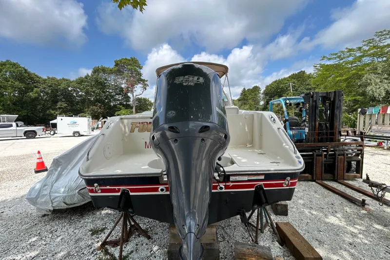 Slide: The Image of 2012 Pursuit DC 265 Dual Console boat with outboard motor on a gravel lot. - 24