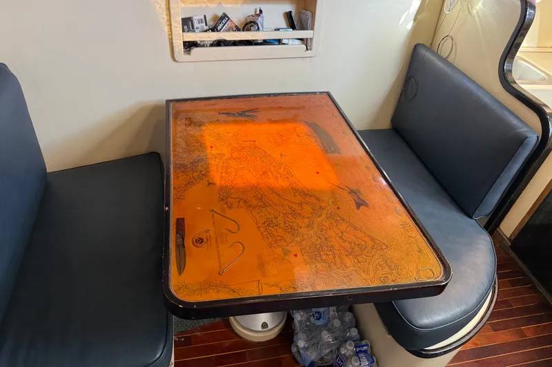 Slide: The Image of Cozy dining area in a 1998 Dorado 36 Express boat with a map-themed table. - 33