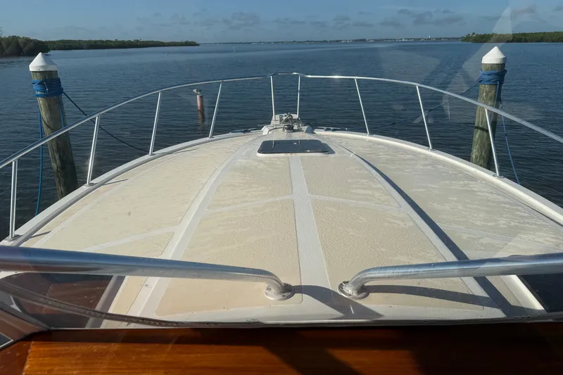 Slide: The Image of Bow view of a 1998 Dorado 36 Express boat docked on calm water. - 26