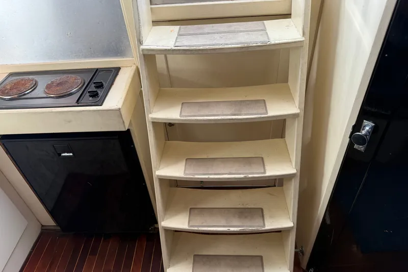Slide: The Image of Interior of 1998 Dorado 36 Express boat with stairs and compact kitchen area. - 44