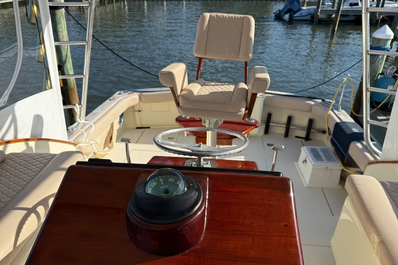 Slide: The Image of 1998 Dorado 36 Express boat interior with helm chair and compass, docked by the water. - 27