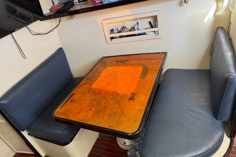 Slide: The Image of Cozy dining area in a 1998 Dorado 36 Express boat with nautical-themed table. - 42