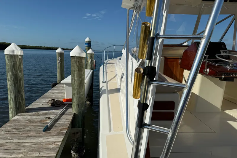 Slide: The Image of 1998 Dorado 36 Express boat docked beside a wooden pier under clear blue skies. - 16