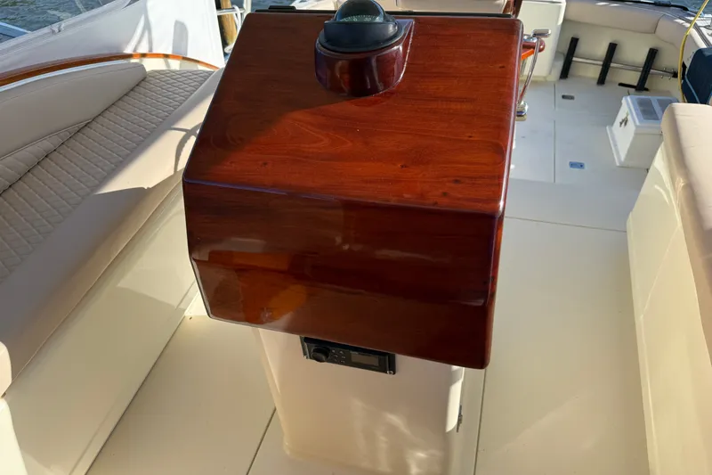 Slide: The Image of Polished wooden helm on 1998 Dorado 36 Express boat, featuring beige seating and nautical equipment. - 25