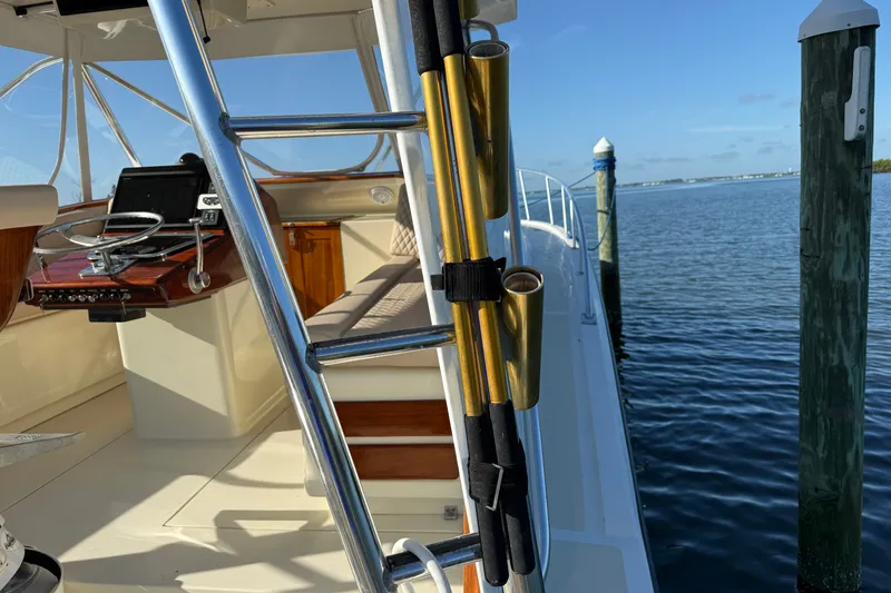 Slide: The Image of 1998 Dorado 36 Express boat interior with steering wheel and rod holders by the dock. - 15
