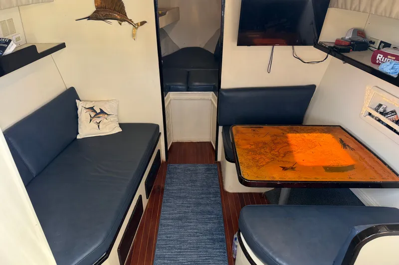 Slide: The Image of Interior of 1998 Dorado 36 Express boat with seating, table, and wall-mounted TV. - 29