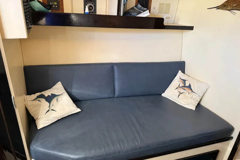 Slide: The Image of Blue cushioned seating with fish-themed pillows in a 1998 Dorado 36 Express cabin. - 35