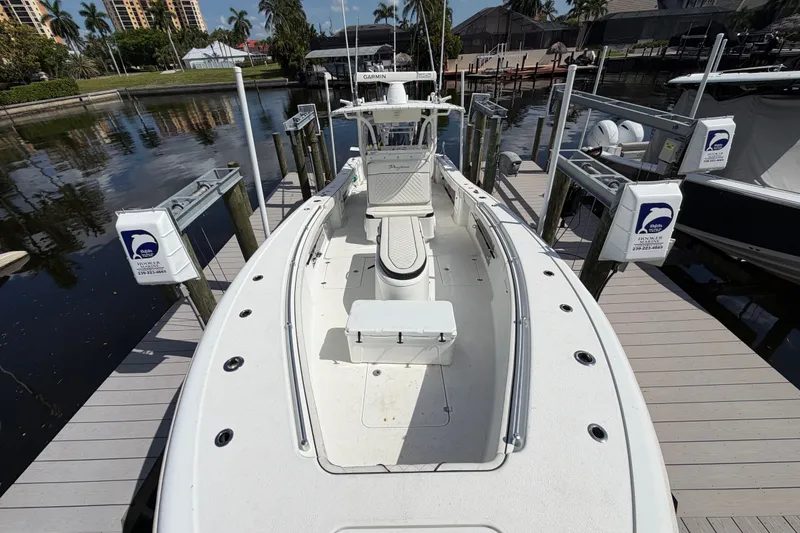 Slide: The Image of 2006 Yellowfin 36 Offshore boat docked at marina, surrounded by water and palm trees. - 7