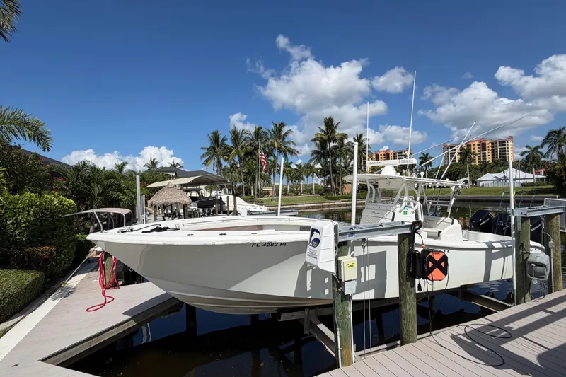 Slide: The Image of 2006 Yellowfin 36 Offshore boat docked under clear blue sky with palm trees. - 1