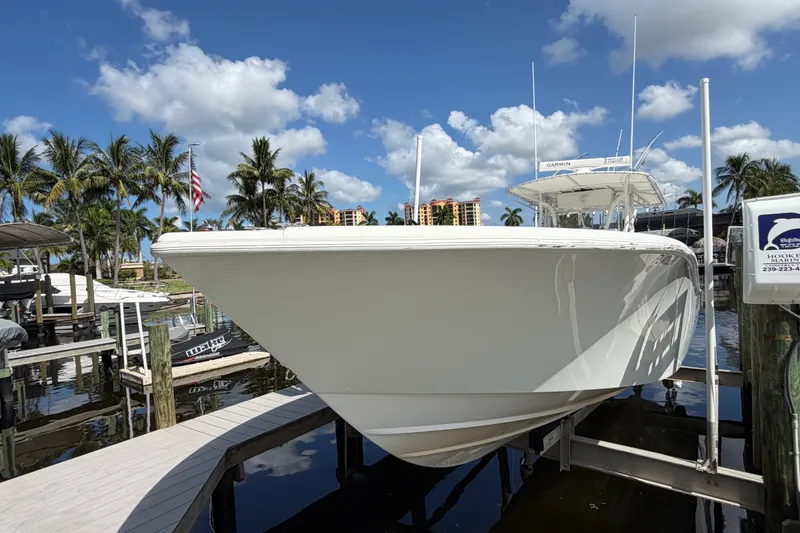 Slide: The Image of 2006 Yellowfin 36 Offshore boat docked, surrounded by palm trees and blue sky. - 3