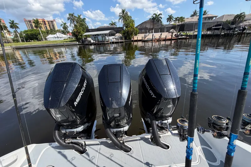 Slide: The Image of 2006 Yellowfin 36 Offshore boat with triple Mercury engines docked by waterfront homes. - 22