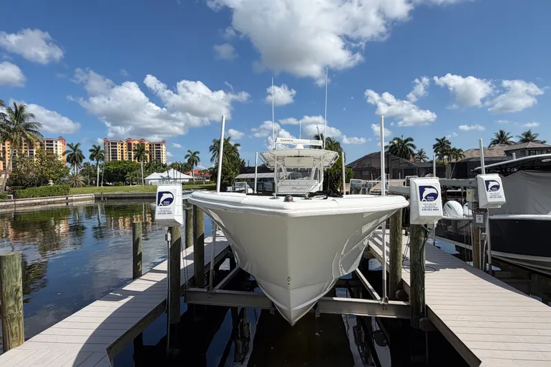 Slide: The Image of 2006 Yellowfin 36 Offshore boat docked in a sunny marina with palm trees. - 5