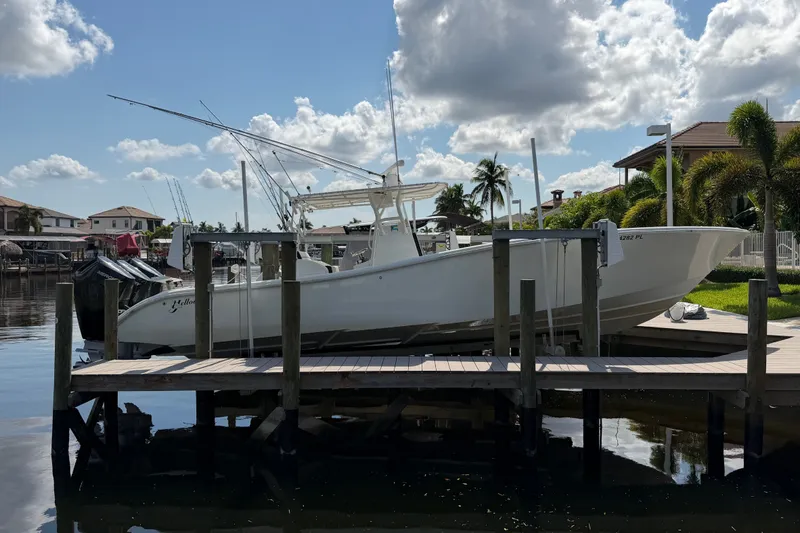 Slide: The Image of 2006 Yellowfin 36 Offshore boat docked at a marina under a partly cloudy sky. - 2
