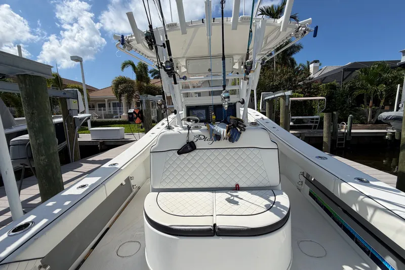 Slide: The Image of 2006 Yellowfin 36 Offshore boat docked, featuring fishing rods and cushioned seating. - 17