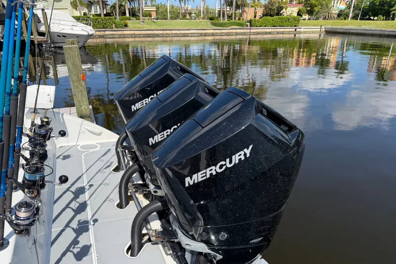 Slide: The Image of 2006 Yellowfin 36 Offshore boat with triple Mercury outboard engines docked by the water. - 6