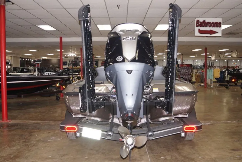 Slide: The Image of 2025 Skeeter ZXR20 boat displayed indoors, rear view with motor and propeller. - 13