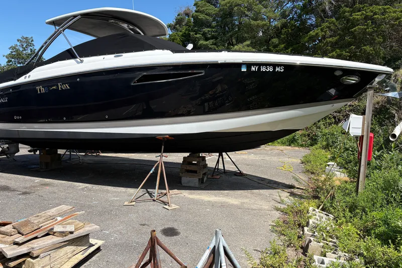 Slide: The Image of 2016 Cobalt 336 boat named "The Fox" on stands, surrounded by greenery. - 7