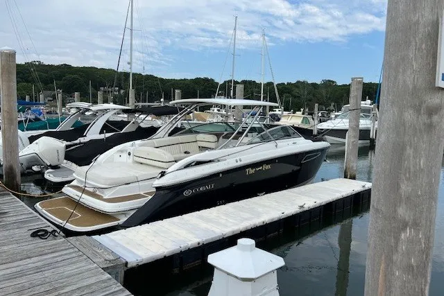 Slide: The Image of 2016 Cobalt 336 boat docked at a marina with other vessels. - 1