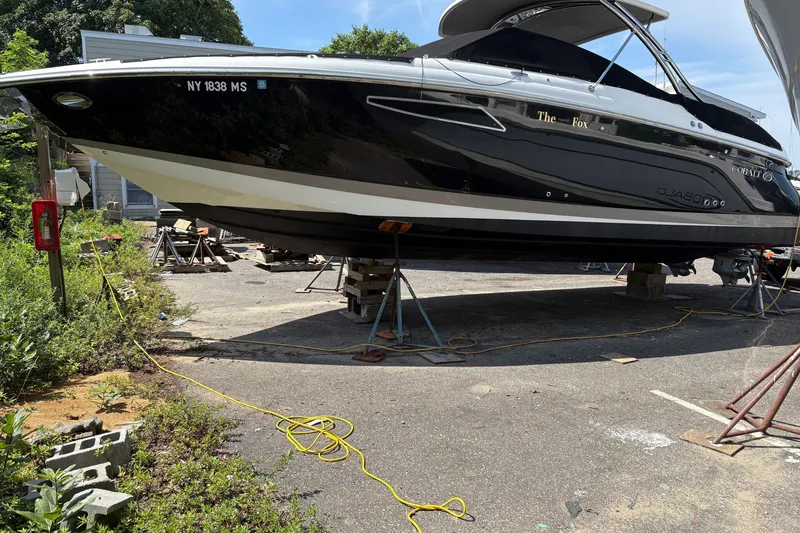 Slide: The Image of 2016 Cobalt 336 boat on stands in a parking lot, surrounded by greenery. - 8