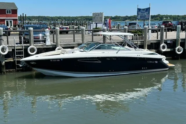 Slide: The Image of 2016 Cobalt 336 boat docked at a marina, calm water, clear day. - 2