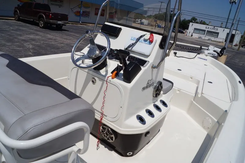 Slide: The Image of 2025 Skeeter SX2250 boat interior with steering console and seating in a parking lot. - 10