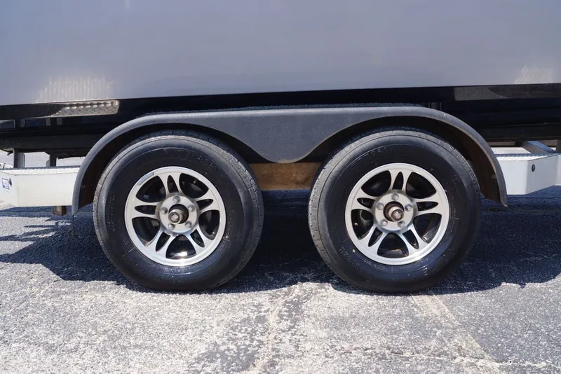 Slide: The Image of Trailer wheels of a 2025 Skeeter SX2250 boat on pavement. - 2