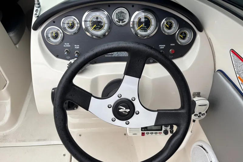 Slide: The Image of Steering wheel and dashboard of a 2010 Sea Ray 185 Sport boat, featuring gauges and controls. - 6