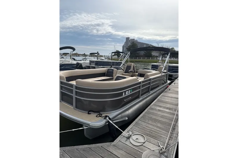 Slide: The Image of 2025 Harris Cruiser 230 pontoon boat docked, featuring spacious seating and sleek design. - 3