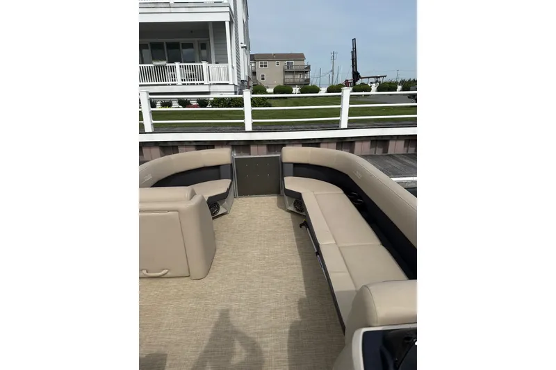 Slide: The Image of 2025 Harris Cruiser 230 boat interior with beige seating and waterfront view. - 8