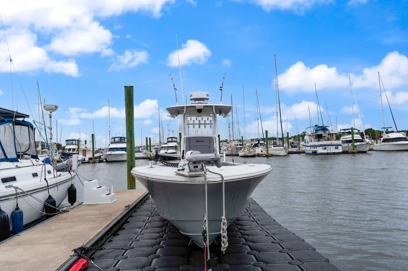 Slide: The Image of 2025 Orion 29 boat docked at a marina, surrounded by sailboats under a blue sky. - 2