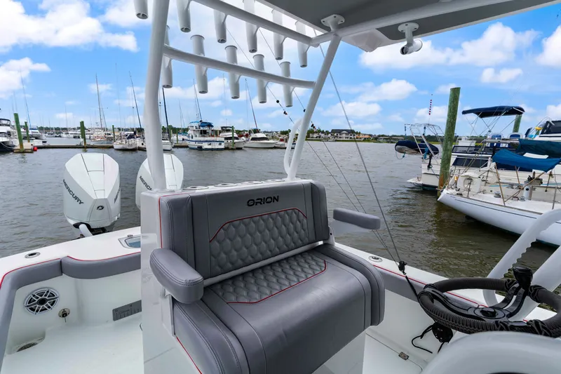 Slide: The Image of 2025 Orion 29 boat interior with luxurious seating and dual Mercury outboard engines at a marina. - 9