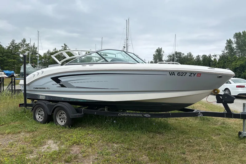 The Image of 2021 Chaparral 21 SSi boat on trailer, parked outdoors with trees in background. - 0
