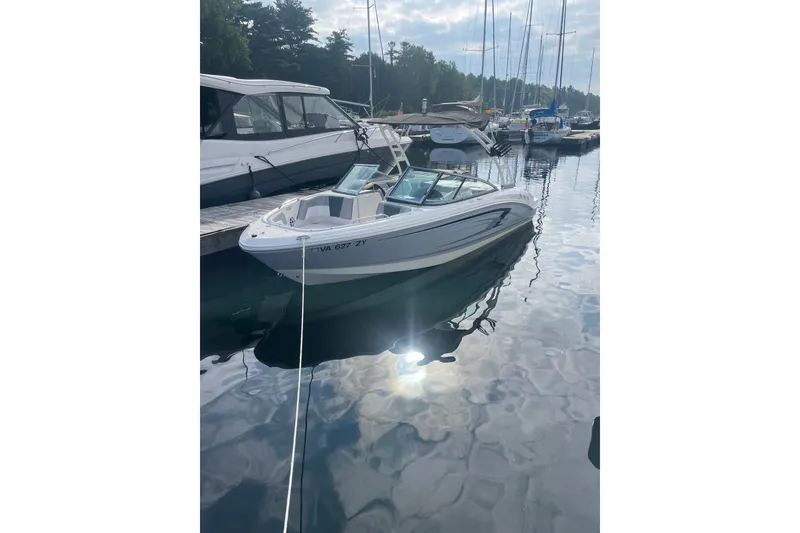 The Image of 2021 Chaparral 21 SSi boat docked in a serene marina setting. - 0