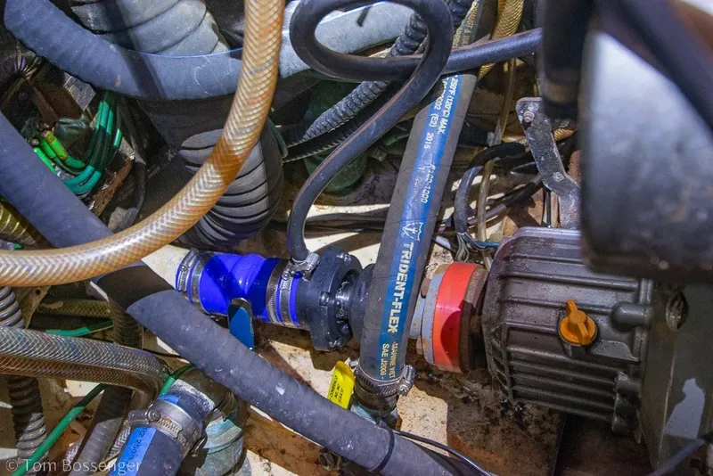 Slide: The Image of Engine compartment of a 1988 Hylas 44 Center Cockpit sailboat, showing hoses and mechanical components. - 82