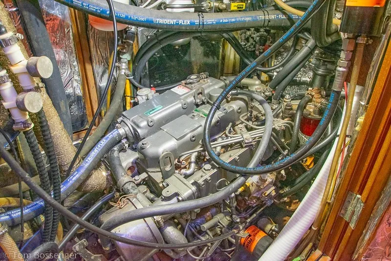 Slide: The Image of Engine room of a 1988 Hylas 44 Center Cockpit sailboat, showcasing complex machinery and hoses. - 79