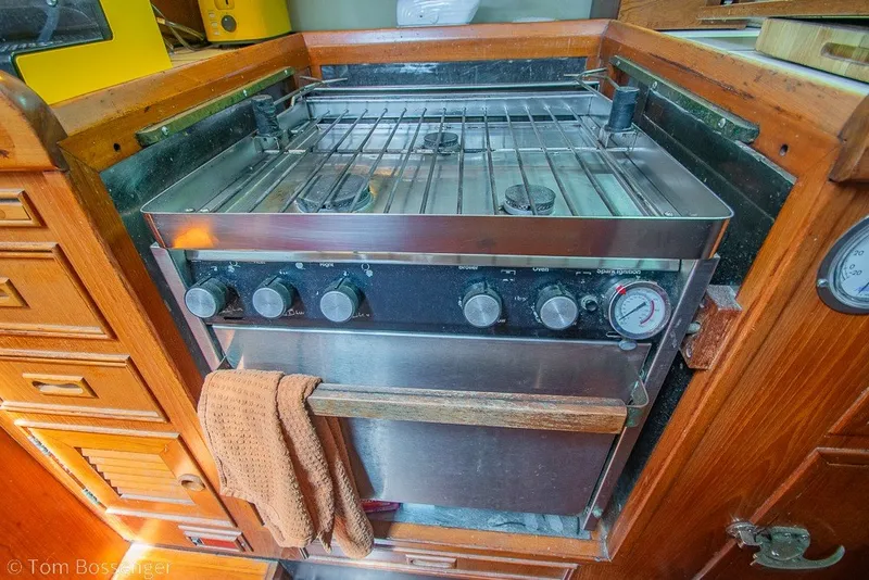 Slide: The Image of Galley stove in 1988 Hylas 44 Center Cockpit yacht, featuring wooden cabinetry and oven controls. - 18