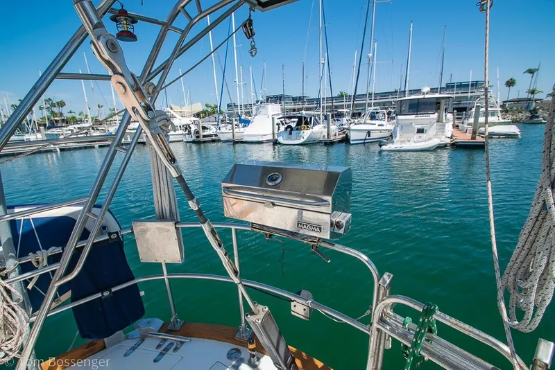 Slide: The Image of Sailboat cockpit view with marina backdrop, featuring a Magma grill. Hylas 44 Center Cockpit, 1988. - 54