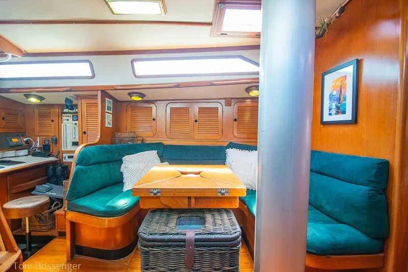 Slide: The Image of Cozy interior of 1988 Hylas 44 Center Cockpit sailboat with green seating and wooden accents. - 13