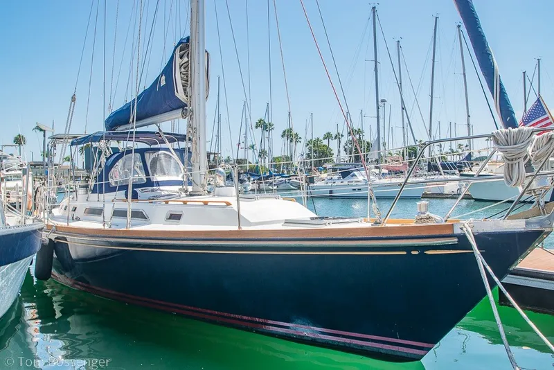 The Image of 1988 Hylas 44 Center Cockpit sailboat docked in a sunny marina. - 0