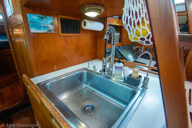 Slide: The Image of Galley sink area in 1988 Hylas 44 Center Cockpit yacht with wooden cabinetry. - 28