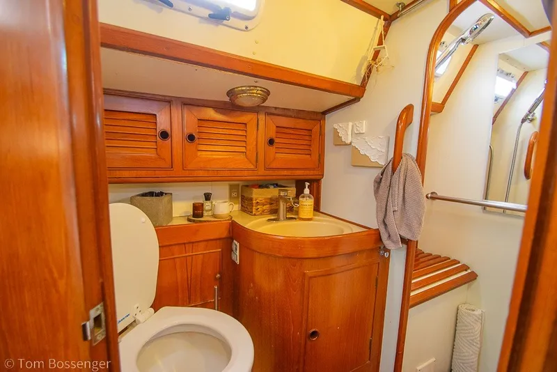 Slide: The Image of 1988 Hylas 44 Center Cockpit bathroom with wooden cabinetry and nautical decor. - 24