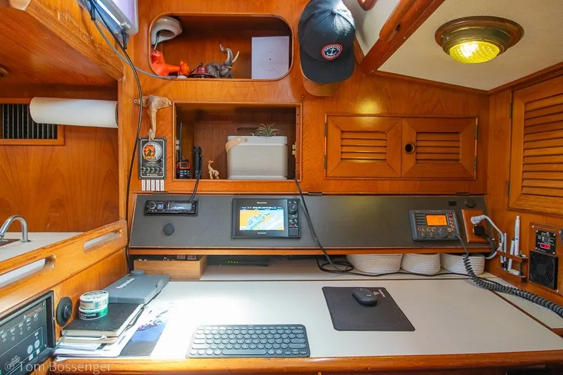 Slide: The Image of Navigation station inside a 1988 Hylas 44 Center Cockpit yacht, featuring wooden cabinetry and electronic equipment. - 34