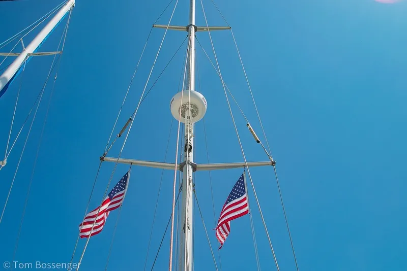 Slide: The Image of Mast of 1988 Hylas 44 Center Cockpit sailboat with American flags against blue sky. - 72