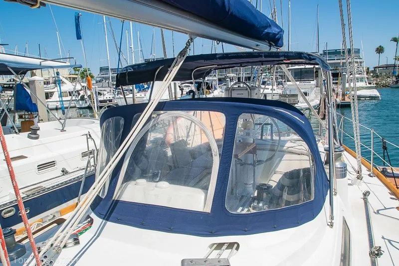 Slide: The Image of 1988 Hylas 44 Center Cockpit sailboat docked in a marina, featuring a blue canopy. - 75